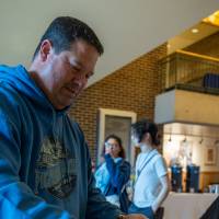 Person grabbing pancakes from warming dish in Kirkhof Center lobby.